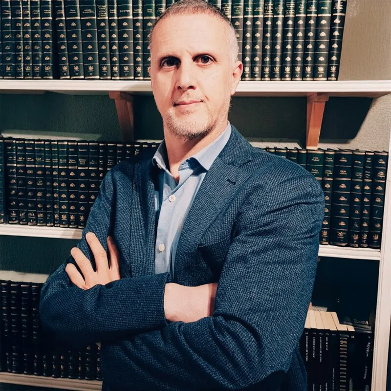Roberto Gallego, fundador y director de Romic Abogados, en su despacho ante una estantería de tomos jurídicos